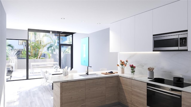 kitchen featuring stainless steel appliances, white cabinetry, and a wealth of natural light