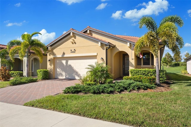 mediterranean / spanish-style house featuring a garage and a front yard