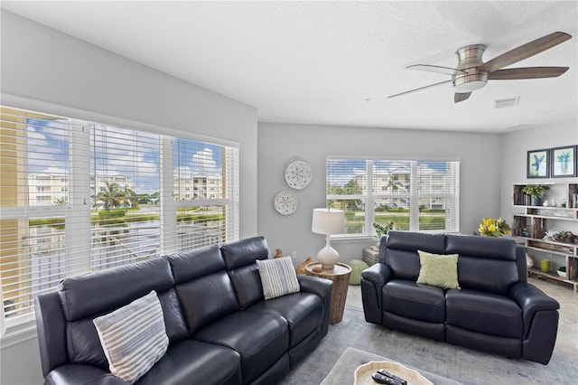 carpeted living room featuring a textured ceiling and ceiling fan