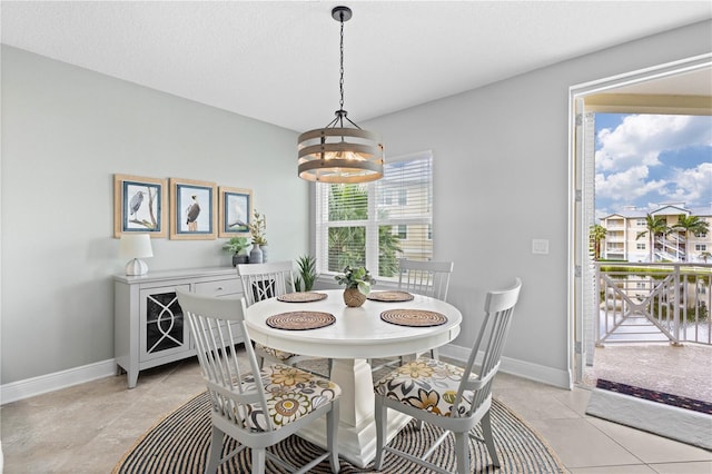 dining room featuring a textured ceiling, light tile patterned flooring, and a notable chandelier