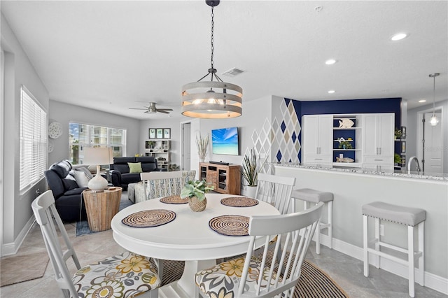 tiled dining area with a textured ceiling and ceiling fan with notable chandelier