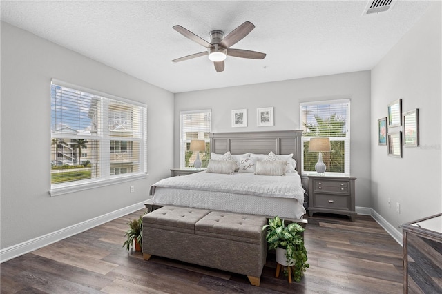 bedroom featuring a textured ceiling, dark wood-type flooring, and ceiling fan