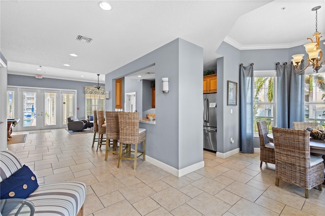 kitchen with a notable chandelier, stainless steel fridge, french doors, and plenty of natural light