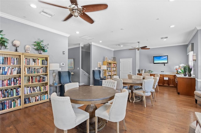 dining space featuring light wood-type flooring, ceiling fan, and crown molding