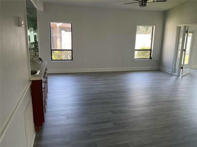 unfurnished living room with dark wood-type flooring and ceiling fan