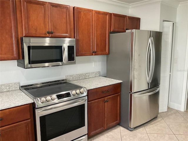 kitchen with ornamental molding, appliances with stainless steel finishes, and light tile patterned floors