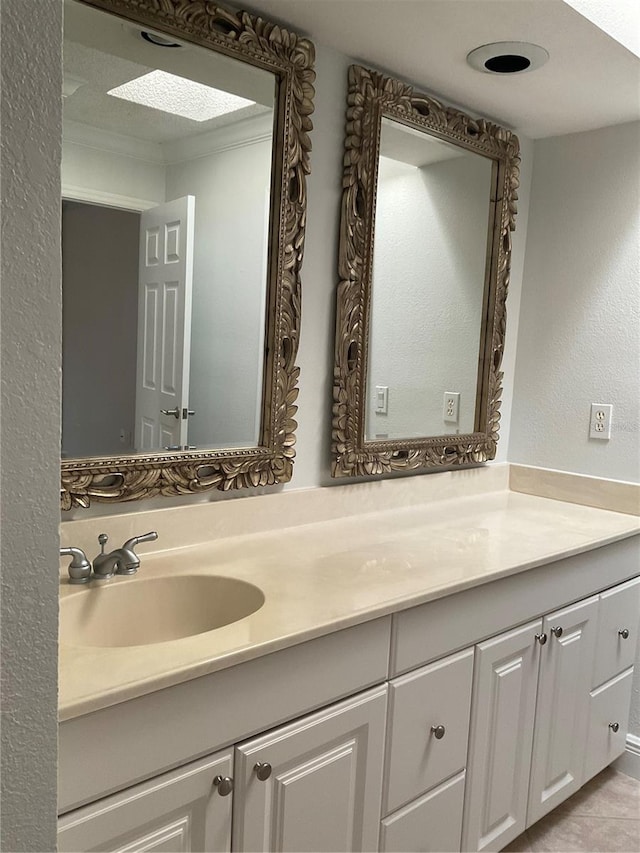 bathroom featuring a skylight, vanity, and tile patterned floors