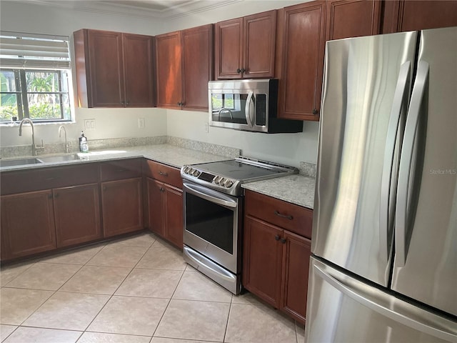 kitchen with a sink, light tile patterned floors, stainless steel appliances, and light countertops