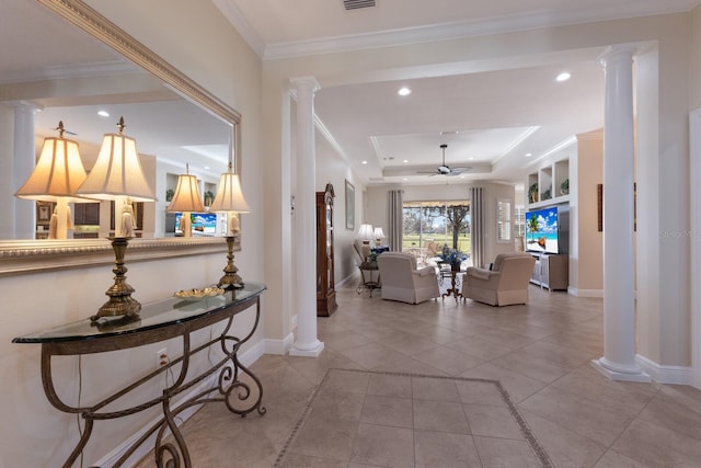 hallway with a raised ceiling, ornate columns, light tile patterned floors, and ornamental molding