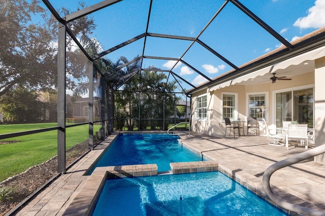 view of swimming pool featuring a lanai, a patio area, ceiling fan, and a lawn