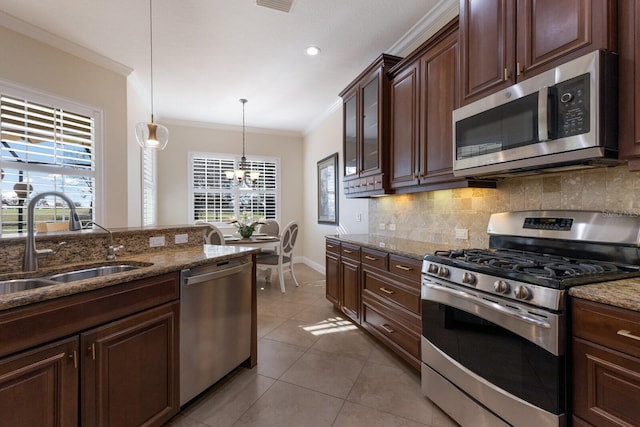 kitchen with a healthy amount of sunlight, sink, hanging light fixtures, and appliances with stainless steel finishes