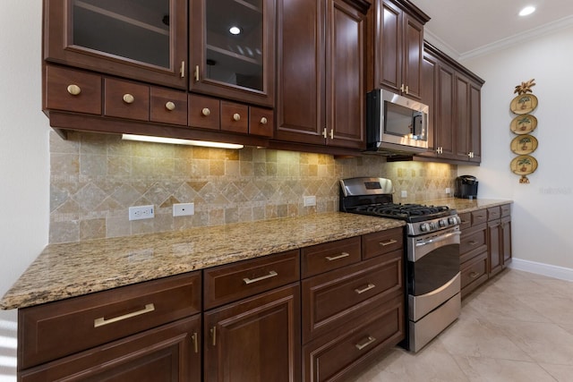 kitchen featuring decorative backsplash, ornamental molding, dark brown cabinets, light stone counters, and stainless steel appliances