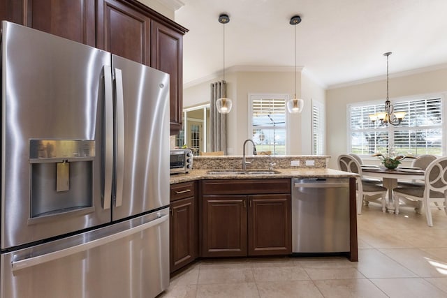 kitchen with crown molding, light stone counters, plenty of natural light, and stainless steel appliances