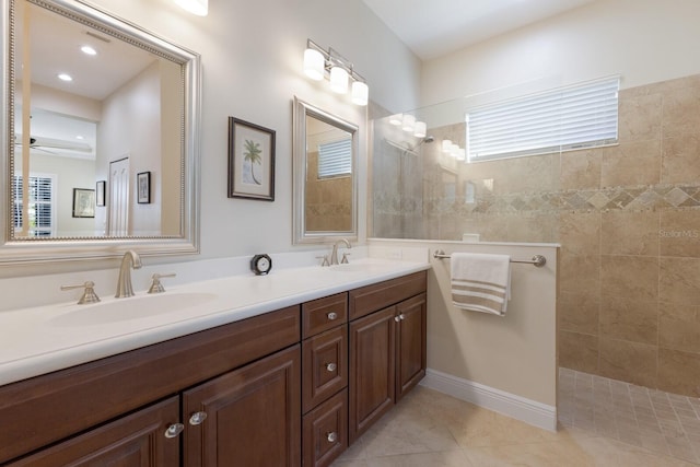 bathroom with tile patterned flooring, vanity, and a tile shower