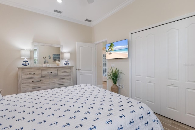 bedroom with crown molding, a closet, ceiling fan, and light hardwood / wood-style flooring