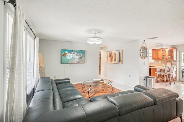 tiled living room featuring a textured ceiling