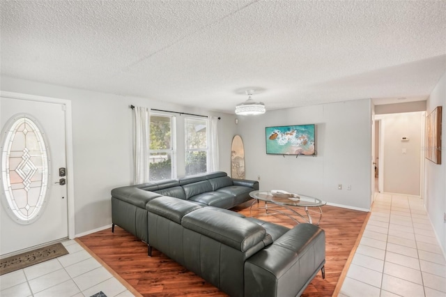 living room with light wood-type flooring and a textured ceiling