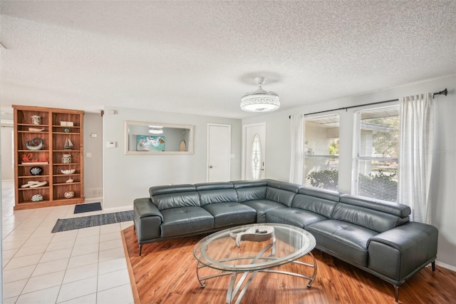 tiled living room with ceiling fan and a textured ceiling