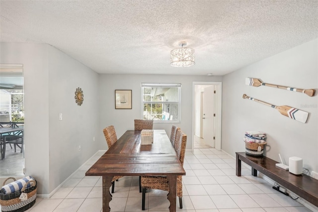 dining room featuring a textured ceiling and light tile patterned flooring