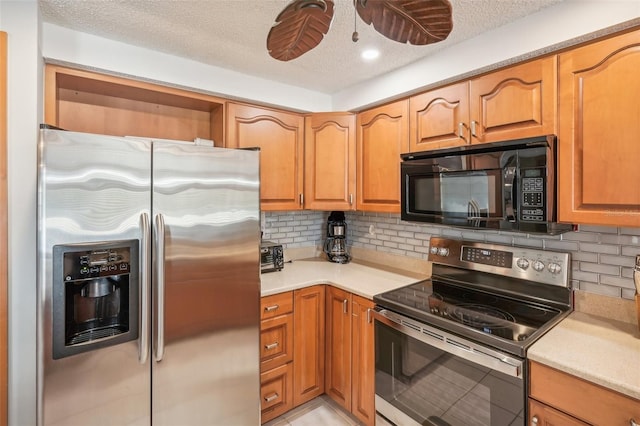 kitchen featuring decorative backsplash, appliances with stainless steel finishes, and a textured ceiling