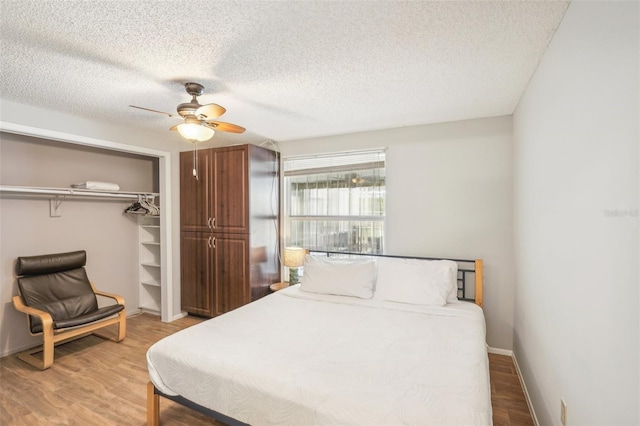 bedroom featuring ceiling fan, a textured ceiling, a closet, and hardwood / wood-style floors