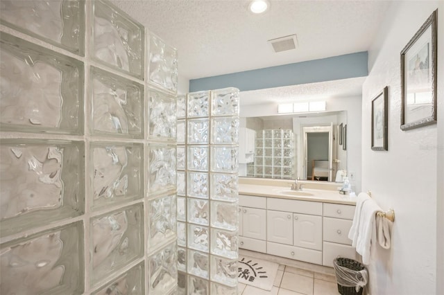 bathroom with vanity, tile patterned flooring, and a textured ceiling