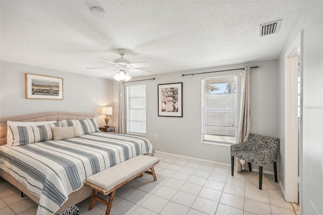 bedroom with ceiling fan, a textured ceiling, and light tile patterned flooring