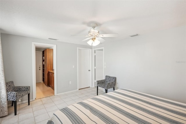 tiled bedroom featuring ensuite bathroom and ceiling fan