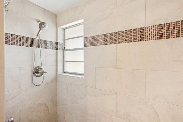 bathroom with tiled shower and a healthy amount of sunlight