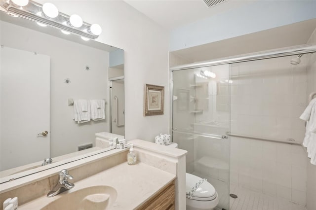 bathroom featuring an enclosed shower, vanity, and toilet