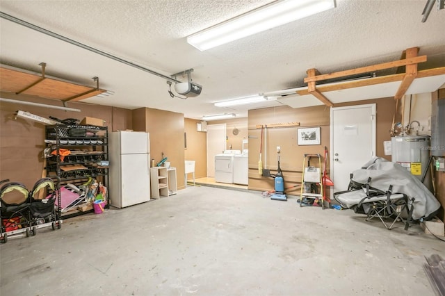 garage featuring washer and clothes dryer, water heater, a garage door opener, and white fridge