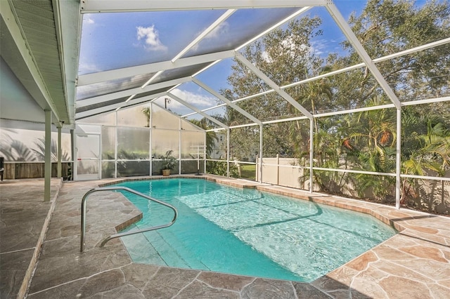 view of pool featuring glass enclosure and a patio area