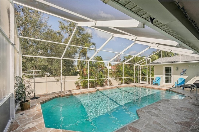 view of swimming pool featuring glass enclosure and a patio