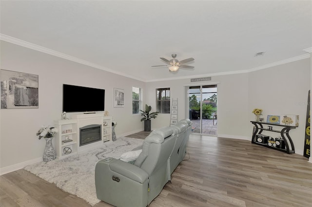 living room featuring crown molding, ceiling fan, and light wood-type flooring