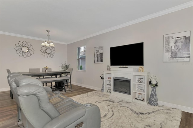 living room featuring dark wood-type flooring, ornamental molding, and a chandelier