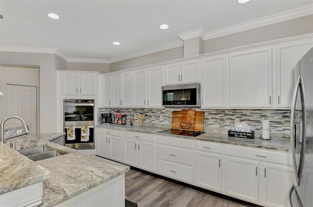 kitchen featuring light stone countertops, appliances with stainless steel finishes, sink, white cabinets, and ornamental molding