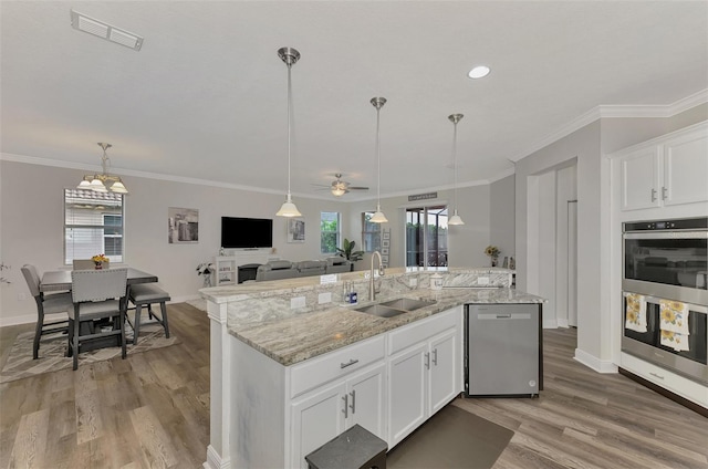 kitchen featuring an island with sink, stainless steel appliances, sink, and white cabinets