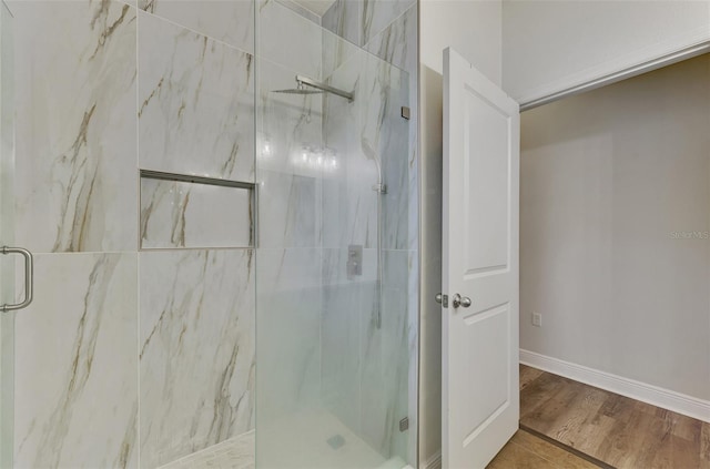 bathroom featuring a shower with door and hardwood / wood-style floors