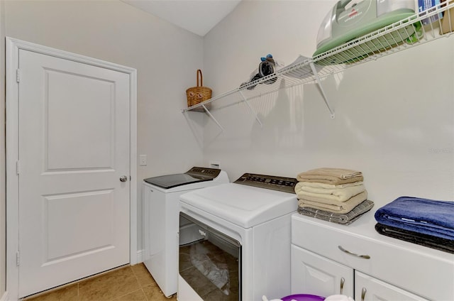 laundry room with cabinets, light tile patterned floors, and independent washer and dryer