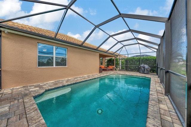 view of pool featuring a patio area, grilling area, and glass enclosure