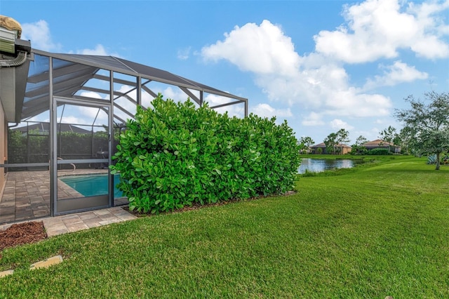 view of yard with a water view and glass enclosure