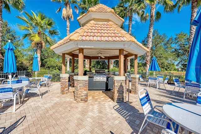 view of patio featuring an outdoor kitchen, a gazebo, grilling area, an outdoor bar, and ceiling fan