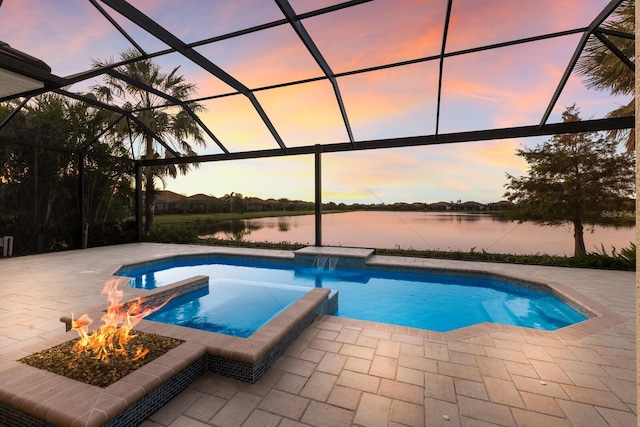 pool at dusk featuring an in ground hot tub, a patio, a water view, and a lanai