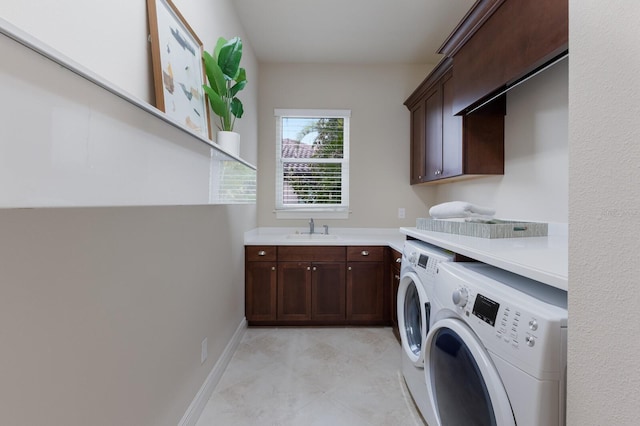 laundry room with cabinets, separate washer and dryer, and sink