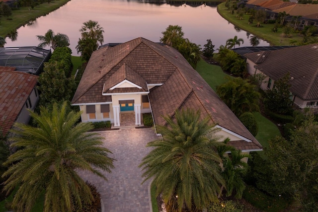 aerial view at dusk featuring a water view