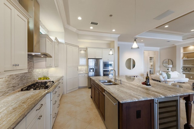 kitchen featuring sink, stainless steel appliances, beverage cooler, a large island with sink, and white cabinets