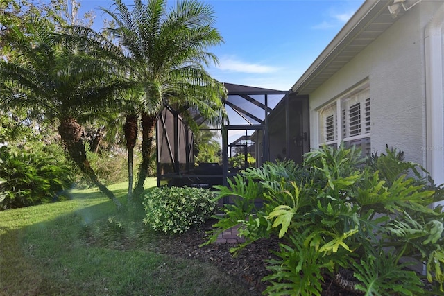 view of home's exterior featuring a lawn and glass enclosure