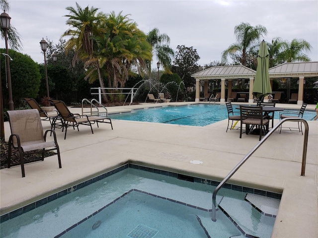 community pool featuring a gazebo, a community hot tub, and a patio area