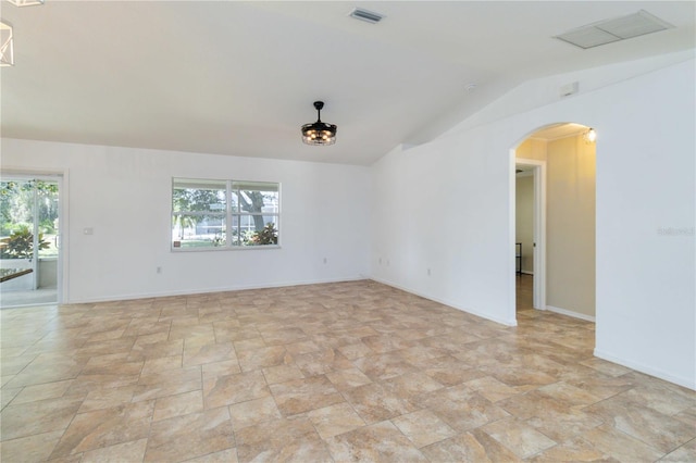 spare room featuring plenty of natural light and vaulted ceiling