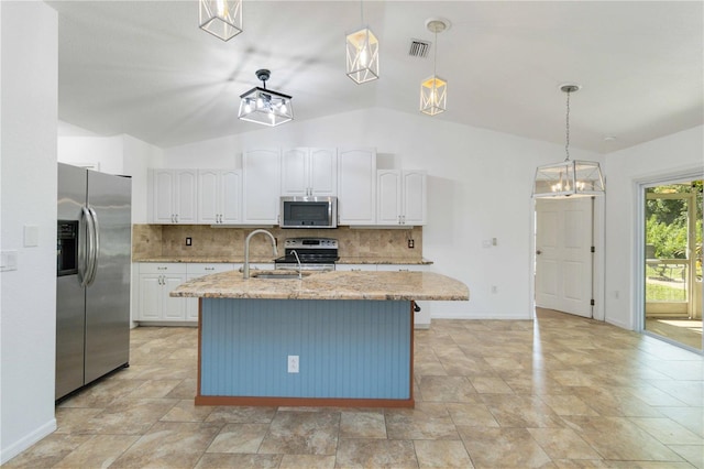 kitchen featuring an island with sink, lofted ceiling, sink, decorative light fixtures, and stainless steel appliances